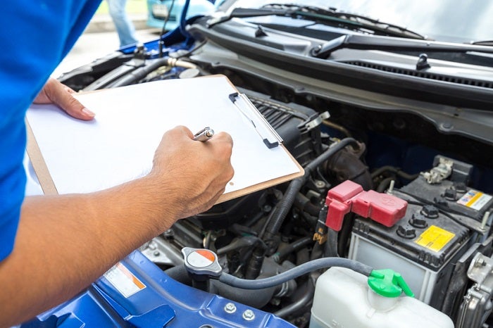 Mechanic checking a service list before Jeep tire replacement near Gallatin TN